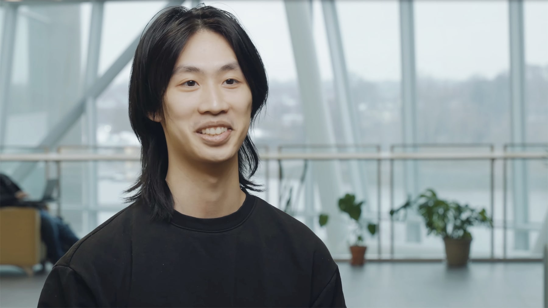 Undergraduate UMass Boston student Jason Lu smiles inside the Integrated Sciences Complex