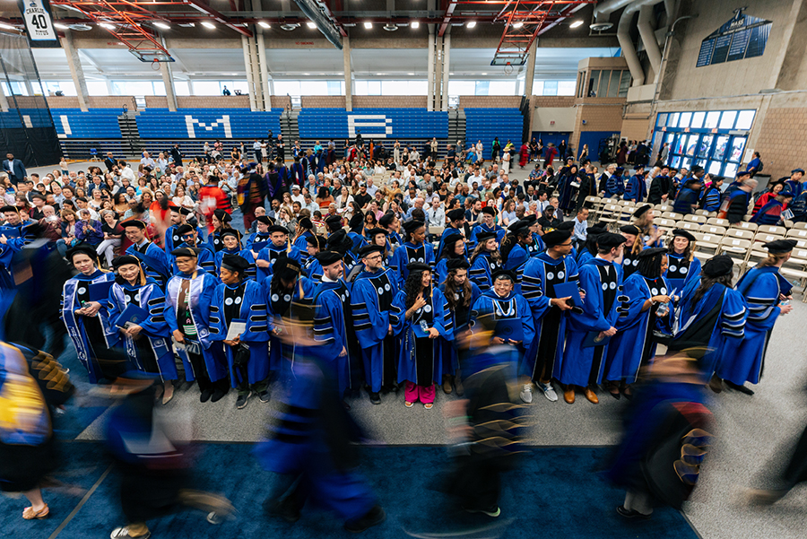 Doctoral candidates walk by at commencement 2025