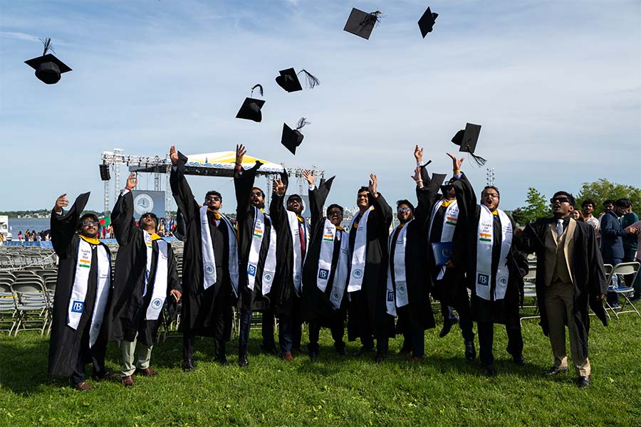 Students tossing their caps in the air at 2025 graduate commencement
