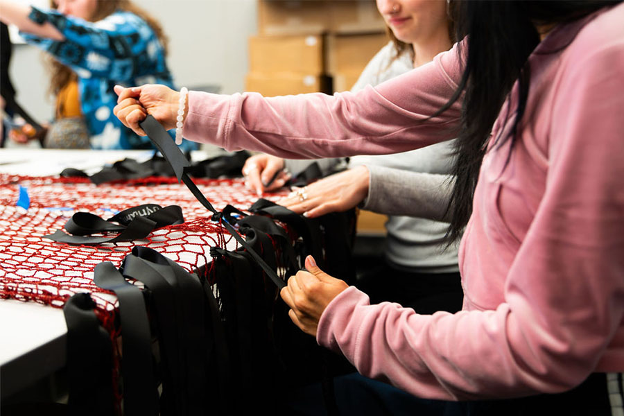 Students tying ribbons on art installation in workshop boston public art triennial