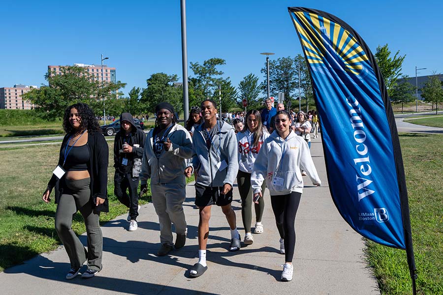 Students walking by welcome sign outside orientation