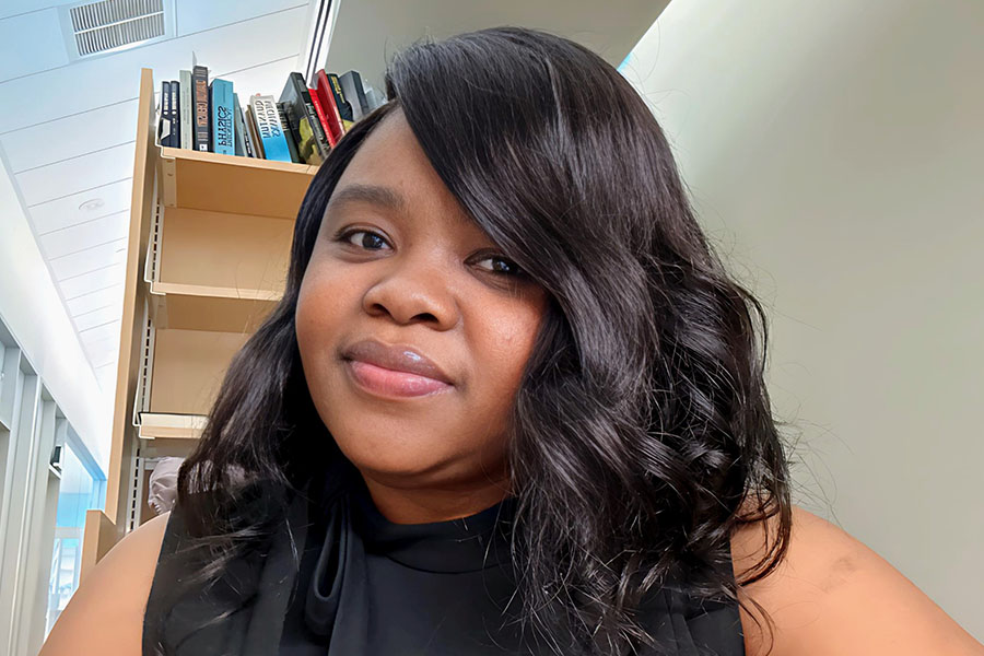 2025 Commencement Speaker Charlotte Kyeremah headshot with books in the background