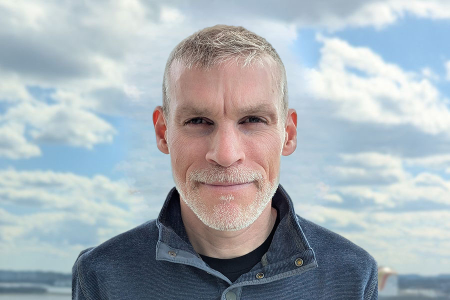 Headshot of professor Liam Revell clouds background Biology professor