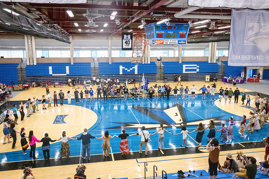 The UMass Boston community and partners gather for a powwow in the gymnasium.