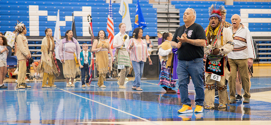 The UMass Boston community and partners gather for a powwow in the gymnasium.