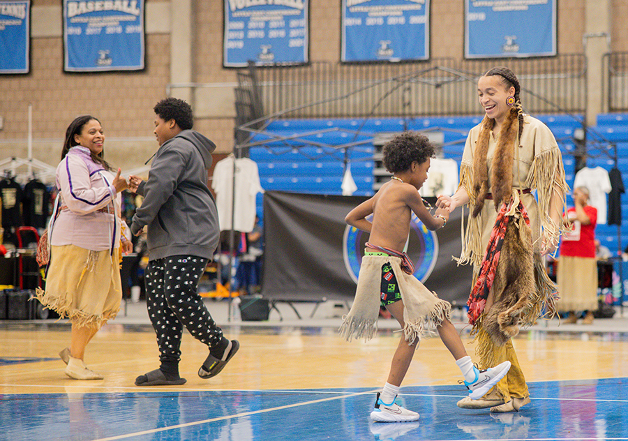 The UMass Boston community and partners gather for a powwow in the gymnasium.