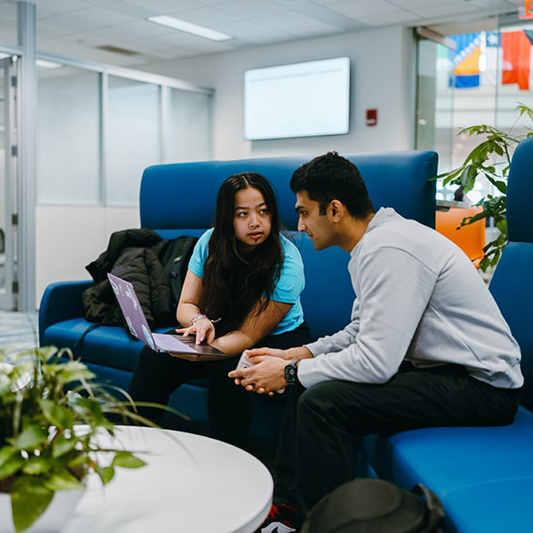 one stop staff assisting student looking at laptop