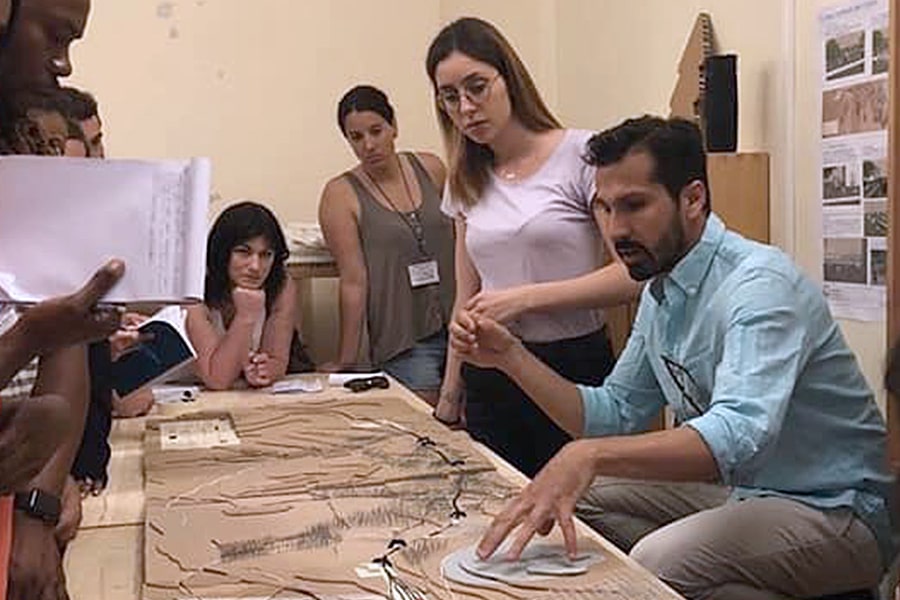 professor Antonio Racit shows students a model of city in Sicily.