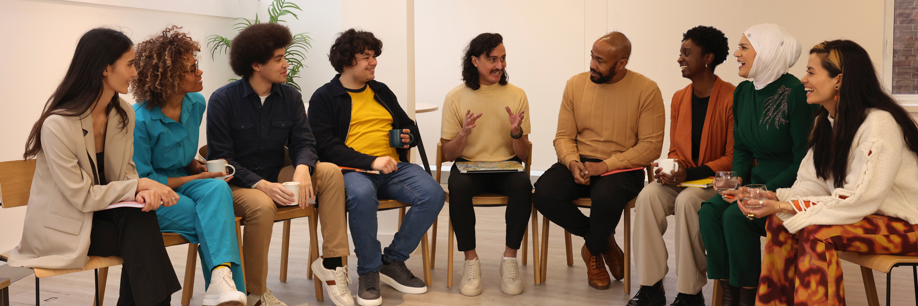 Creative workers in office;ÊMultiethnic grroujp of creative workers sitting and talking in semi circle